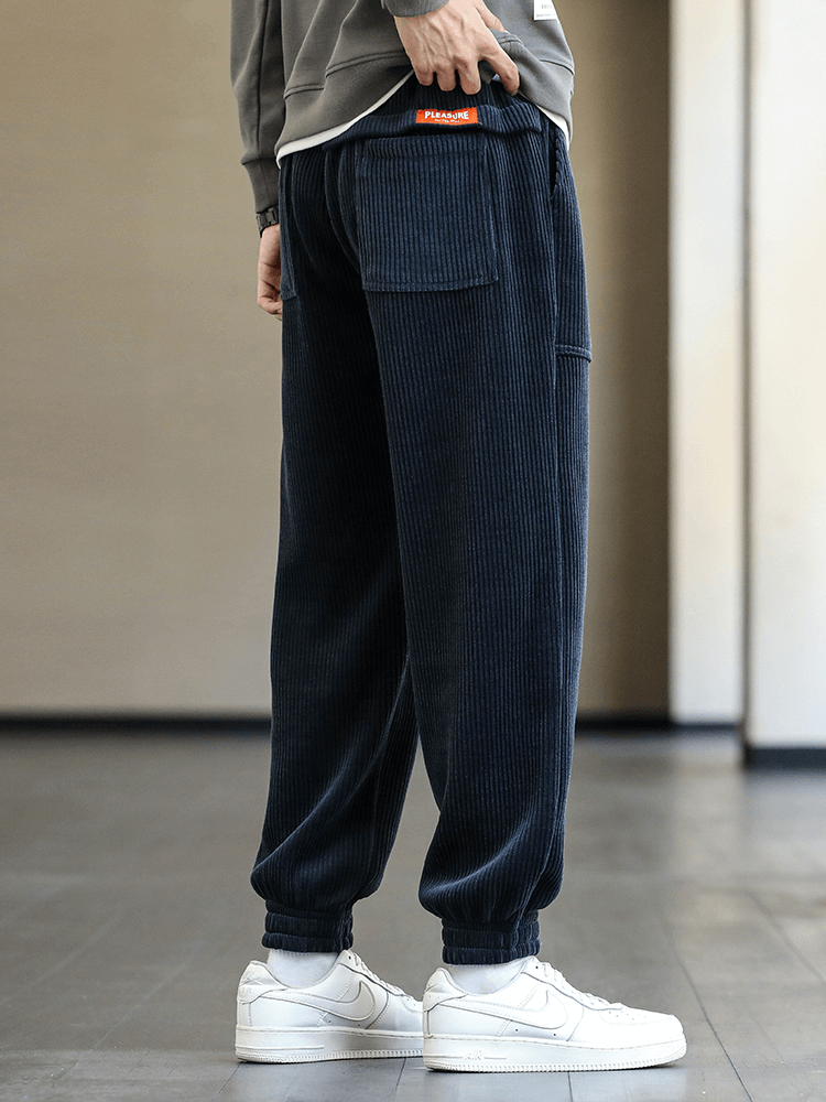 Men's fashion elastic hem corduroy sweatpants, loose fit, side view with jogger style, navy blue color, comfortable and stylish wear.